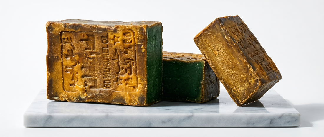 Cross-section of aged Avlia Aleppo soap showing golden-brown exterior and green interior core demonstrating natural chlorophyll oxidation and maturation