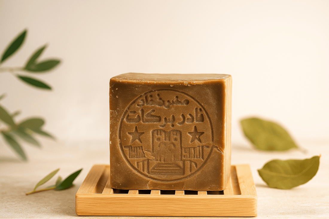 Rustic handmade Aleppo soap bar on a wooden soap dish with olive branches and laurel leaves in a spa-inspired natural setting.