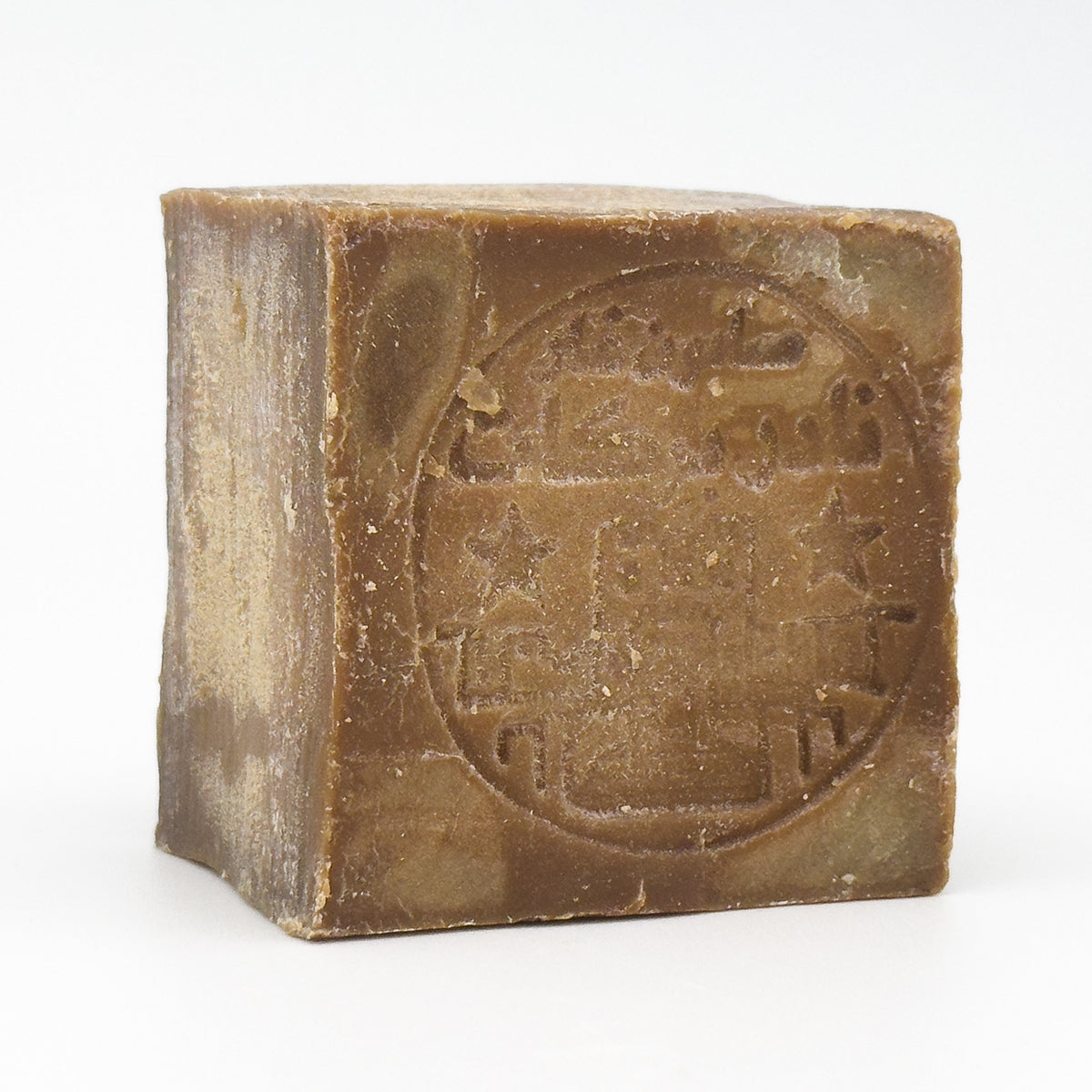 Angled perspective of the unwrapped Aleppo soap bar showing the rustic texture and thickness of the block