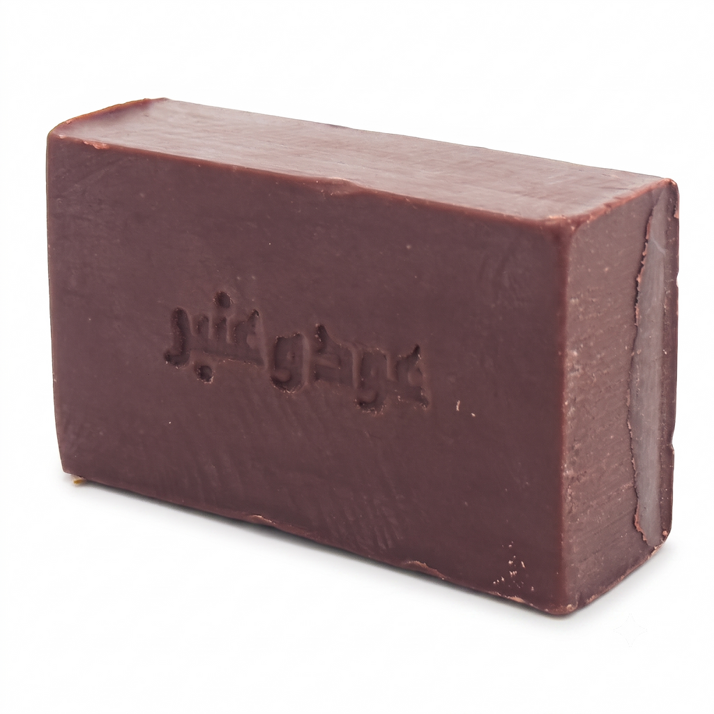 Angled perspective of Avlia Oud & Anbar soap showing the rectangular shape and dark chocolate-colored texture