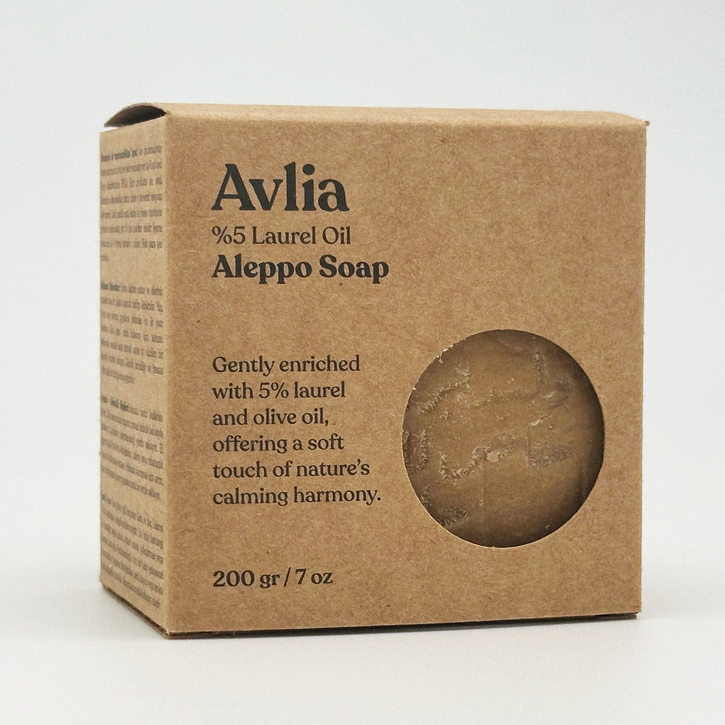 A three-quarter view of the Avlia soap box from the left side, showcasing the front branding and the multilingual product information printed on the side panel