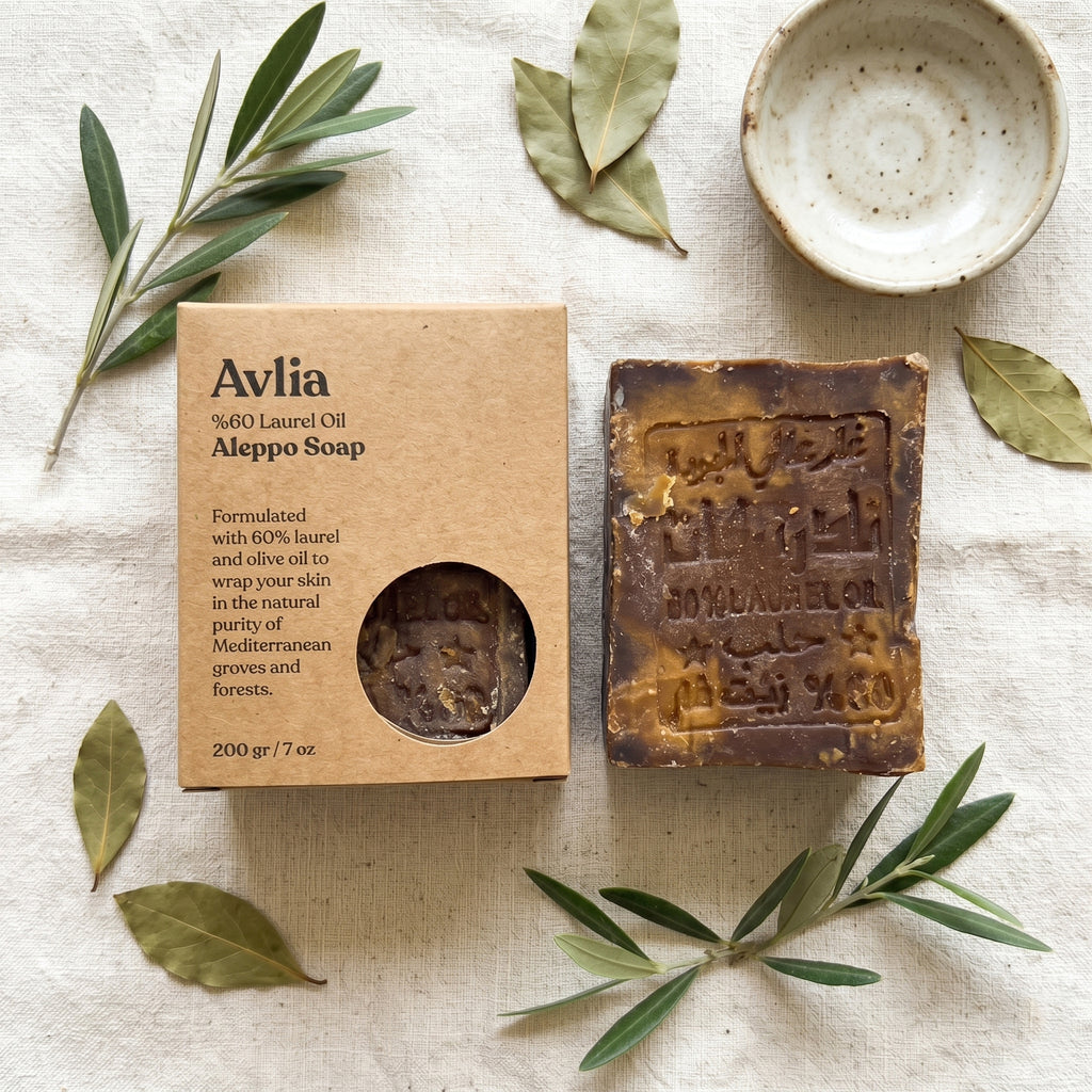 Avlia 60% Laurel Oil Aleppo Soap and kraft box overhead flat lay with olive branches and bay laurel leaves on linen, natural handmade soap product photography