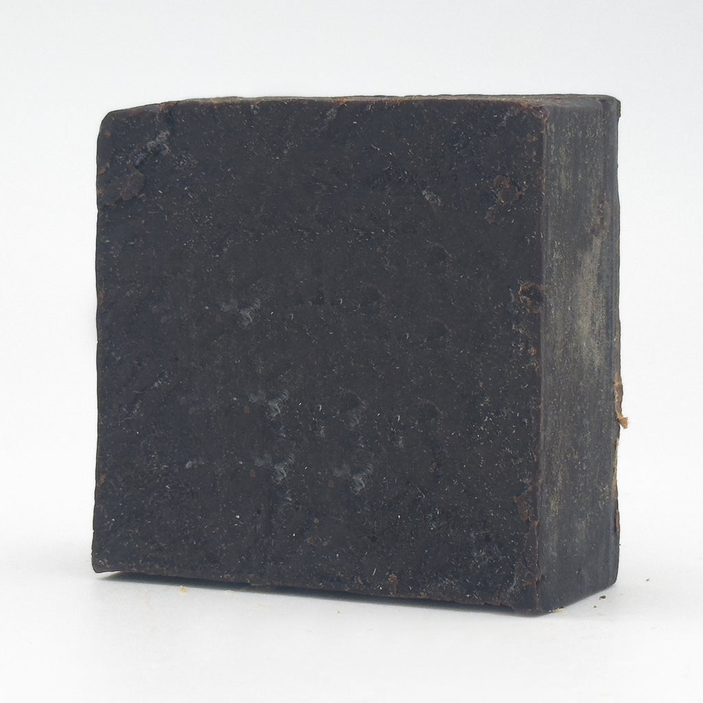 Avlia Pine, Juniper Tar & Sulfur Soap Bar — angled view revealing the hand-cut side edge and matte flecked texture, handmade tar soap on white background