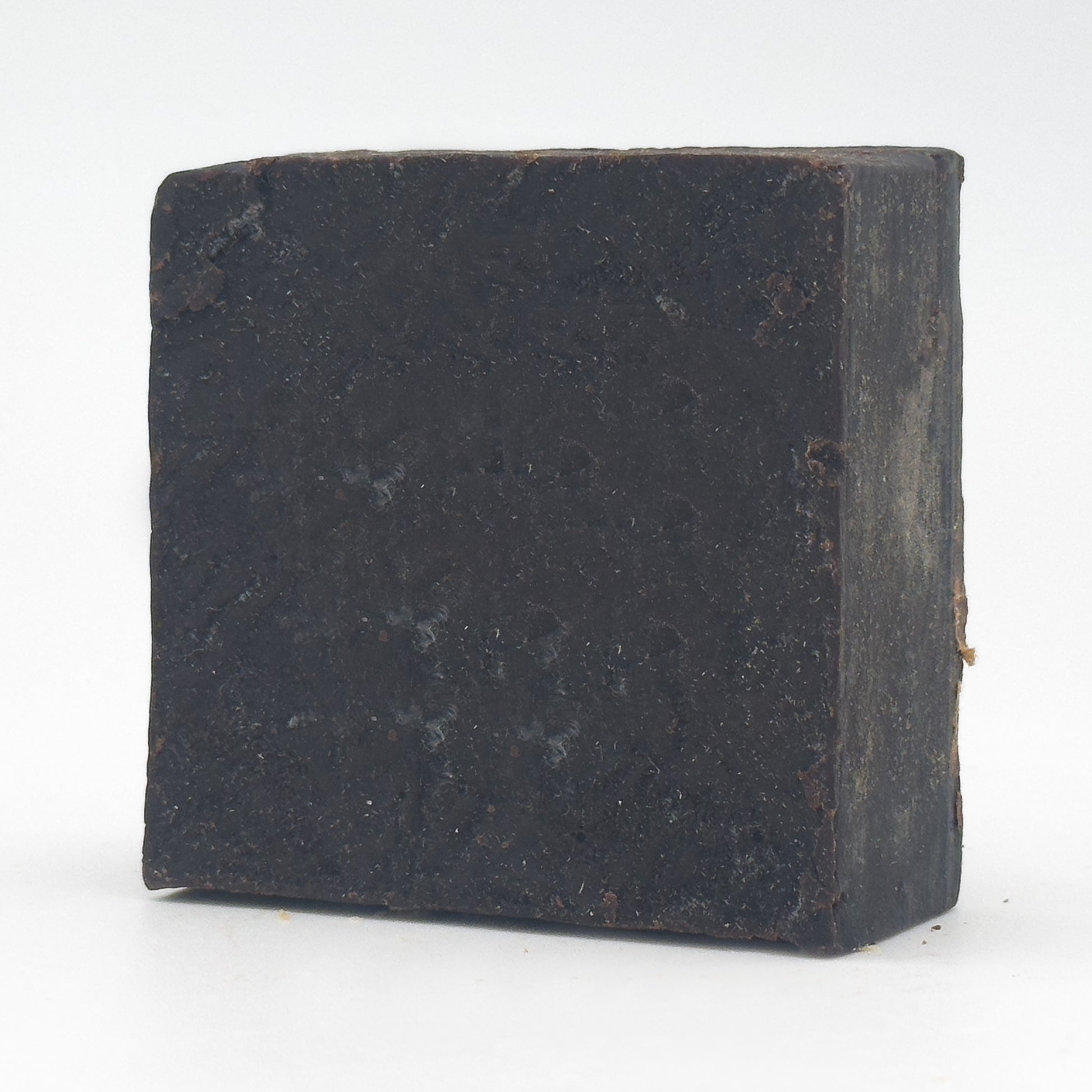 Avlia Pine, Juniper Tar & Sulfur Soap Bar — angled view revealing the hand-cut side edge and matte flecked texture, handmade tar soap on white background