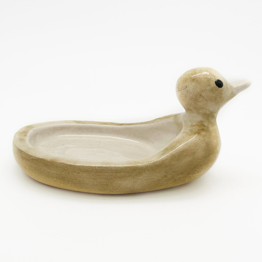 Avlia ceramic duck soap dish photographed low from the side, showing the flat unbroken base that sits level on a basin surround