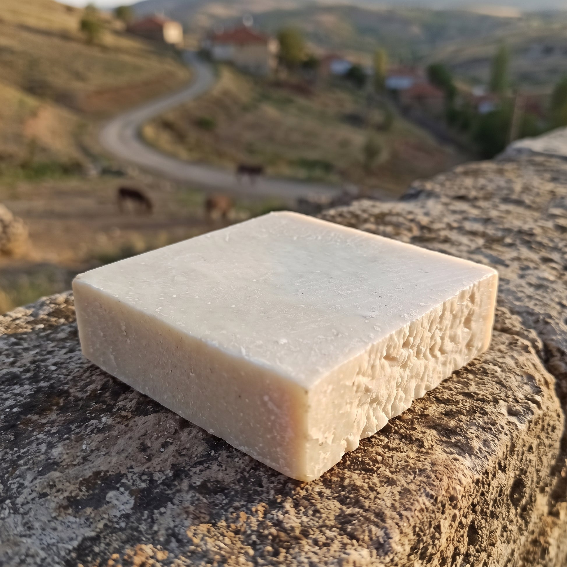 Avlia donkey milk soap on a stone wall, Anatolian village countryside styling.