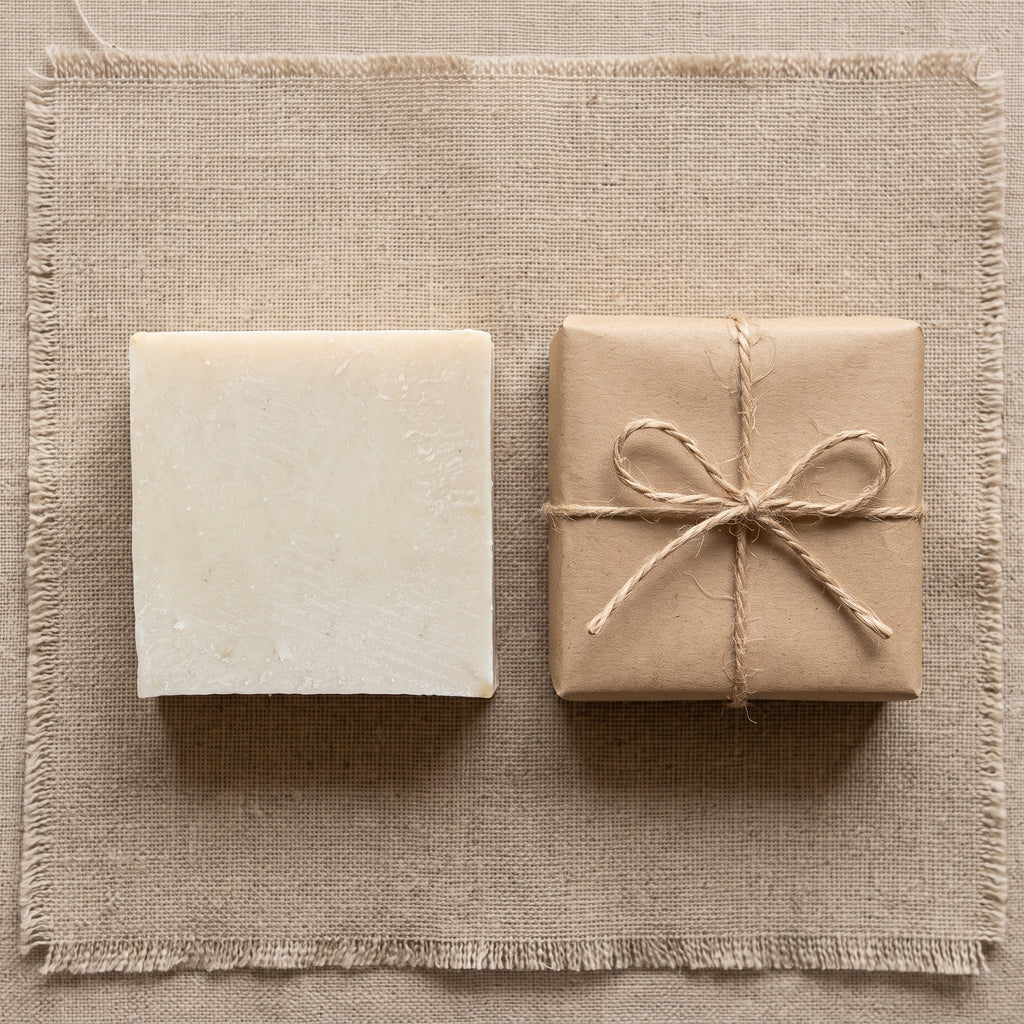 Avlia donkey milk soap with plain kraft wrap and jute twine, minimal packaging flatlay.