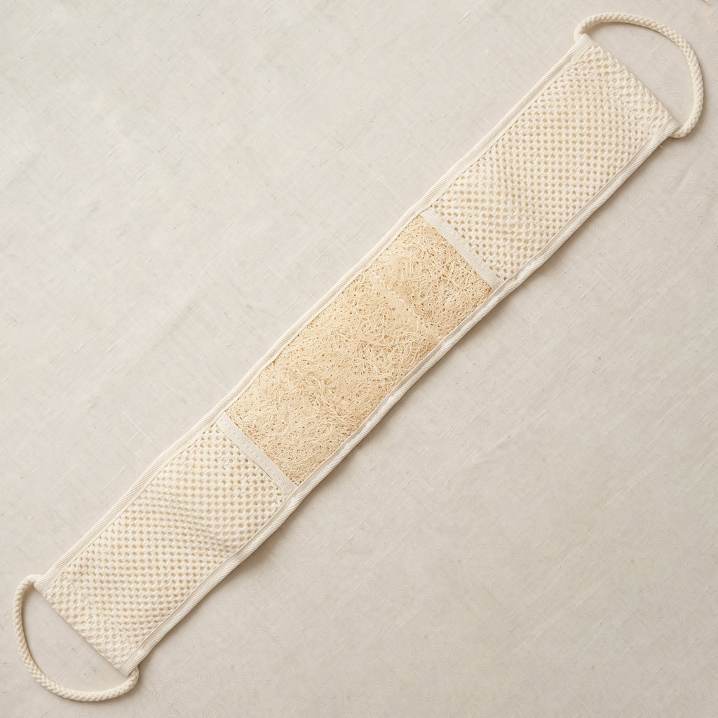 Avlia extra long loofah back strap laid flat, showing the three zones on its working face — waffle-knit cotton, a centred loofah panel, then waffle-knit again