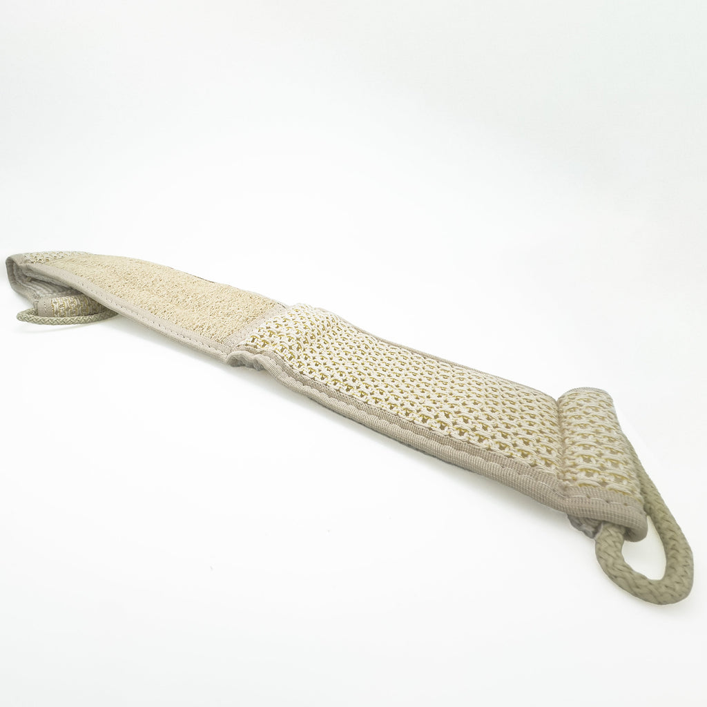 Avlia extra long loofah back strap seen at an angle along its length, the centred loofah panel meeting the waffle-knit cotton zone at a stitched seam