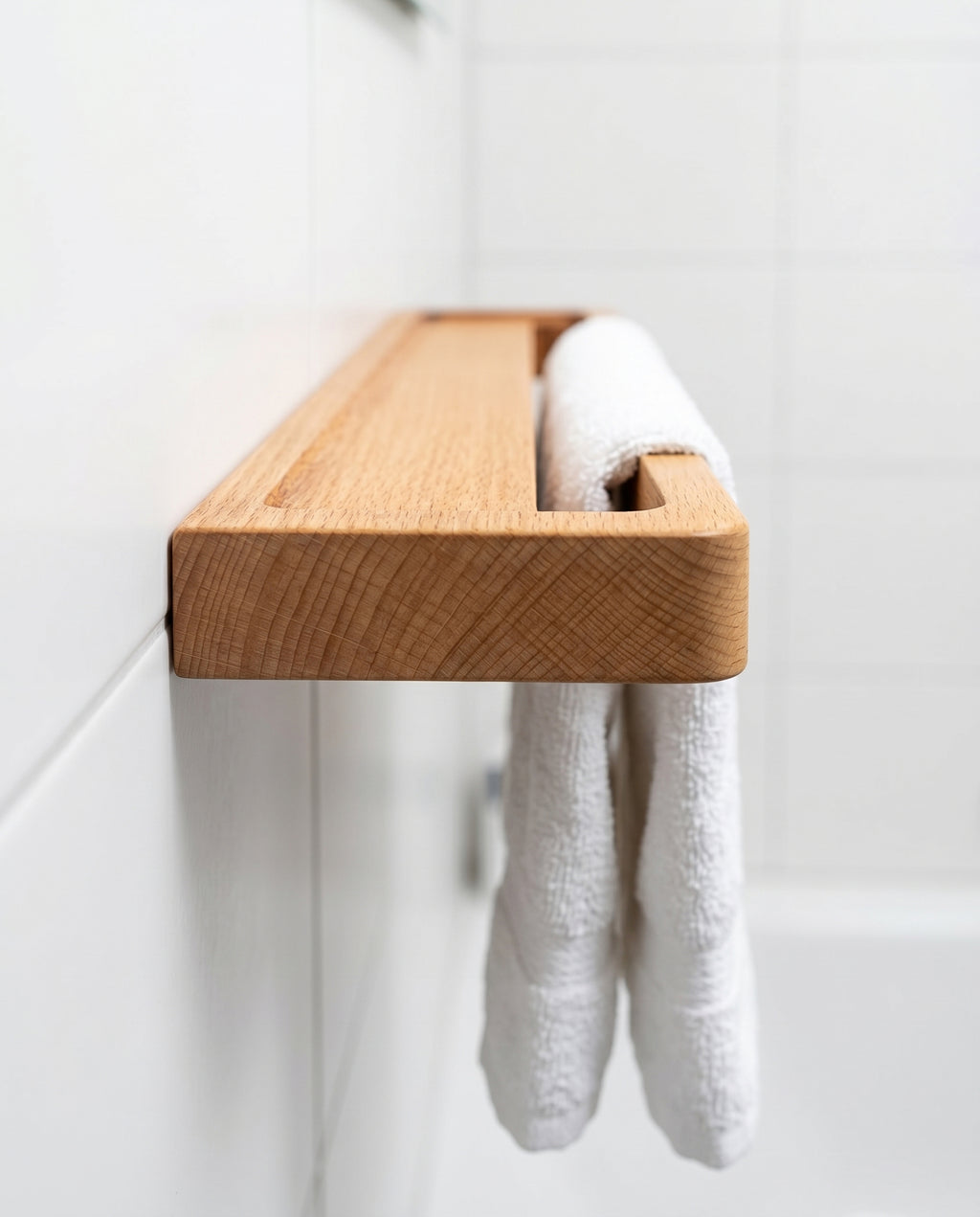 Avlia beechwood towel shelf in boutique hotel bathroom beside mirror, white hotel towel hanging below floating shelf, premium wall-mounted bathroom amenity