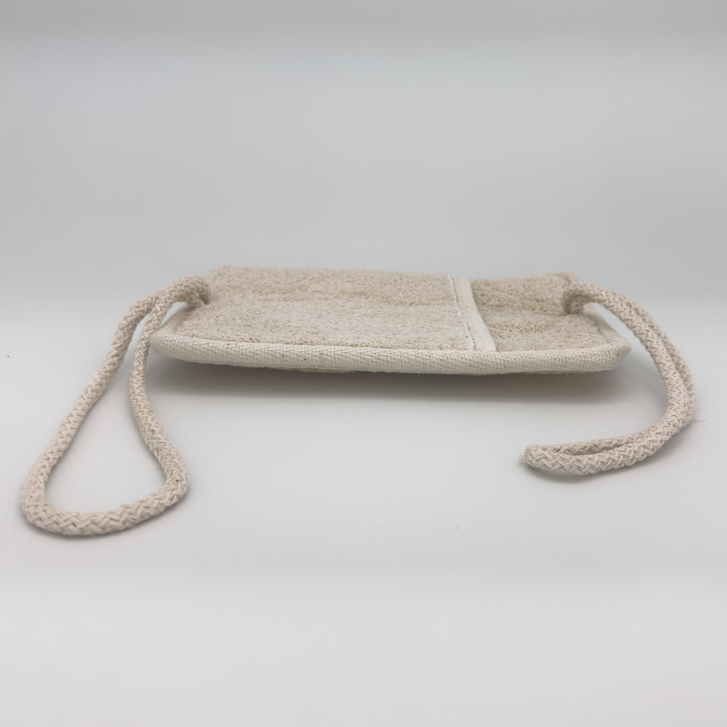 Back of the Avlia loofah bath pad showing the cotton terry face and the sewn hand pocket, opening toward one short end, dual-mode exfoliator