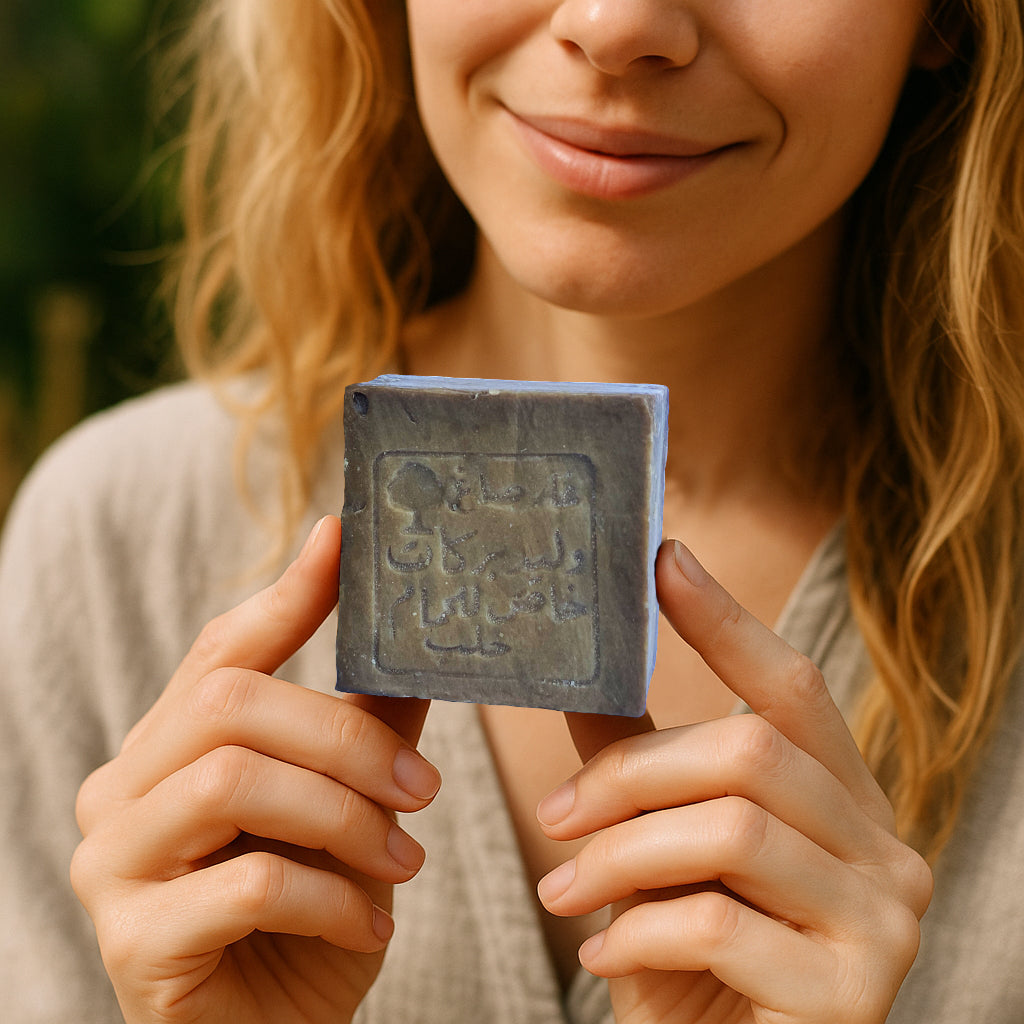 Blonde woman holding traditional olive and laurel oil soap cube