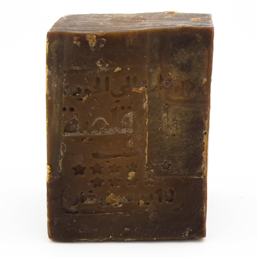 Close-up angled view of the Avlia soap bar, focusing on the stamped logo details and the soap's aged surface Portrait