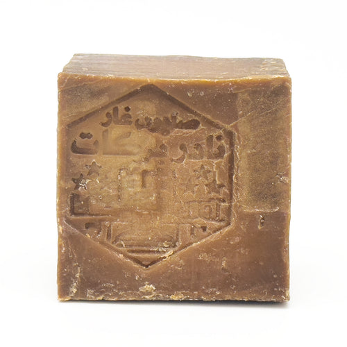 Close-up of rustic Avlia Aleppo soap block with traditional Arabic seal