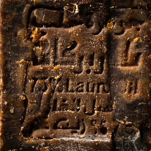 Extreme close-up of traditional Arabic stamp on Avlia Aleppo Soap, centuries-old hand-pressed seal