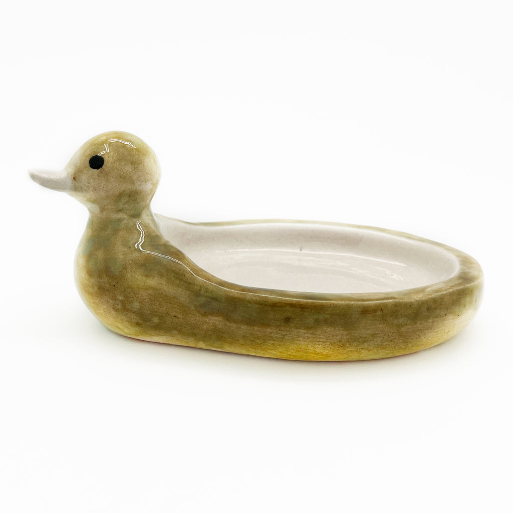 Full profile of the Avlia ceramic duck soap dish facing right, the softly irregular outline showing that the piece was built by hand, not moulded