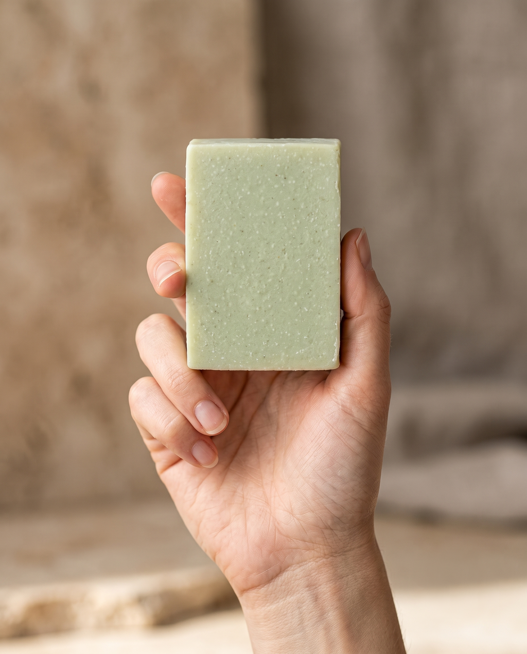 Hand holding Aloe Vera Soap against a soft neutral background, showing the size of the bar