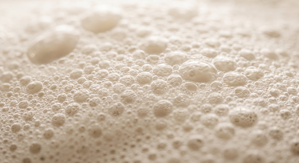 Macro close-up of rich, creamy lather bubbles from the Avlia donkey milk soap.