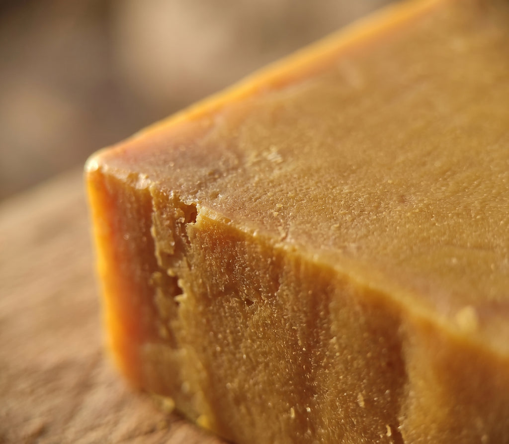 Macro close-up of the Pure Sulfur Soap's rough hand-cut edge and golden-amber texture.