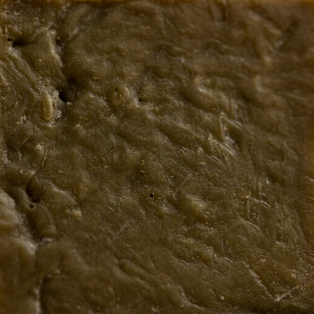 Macro close-up of the laurel oil bar's natural texture and olive-green-to-brown color.