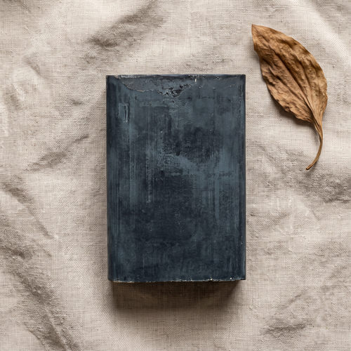 Avlia African Black Soap Bar flat-lay on natural linen with dried plantain leaf