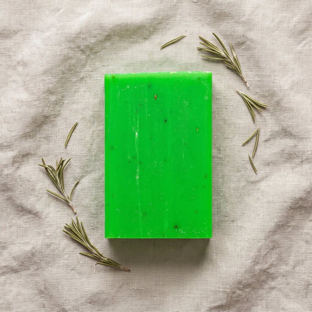 Overhead flat-lay of Rosemary Soap Bar on wrinkled natural linen with dried rosemary sprigs
