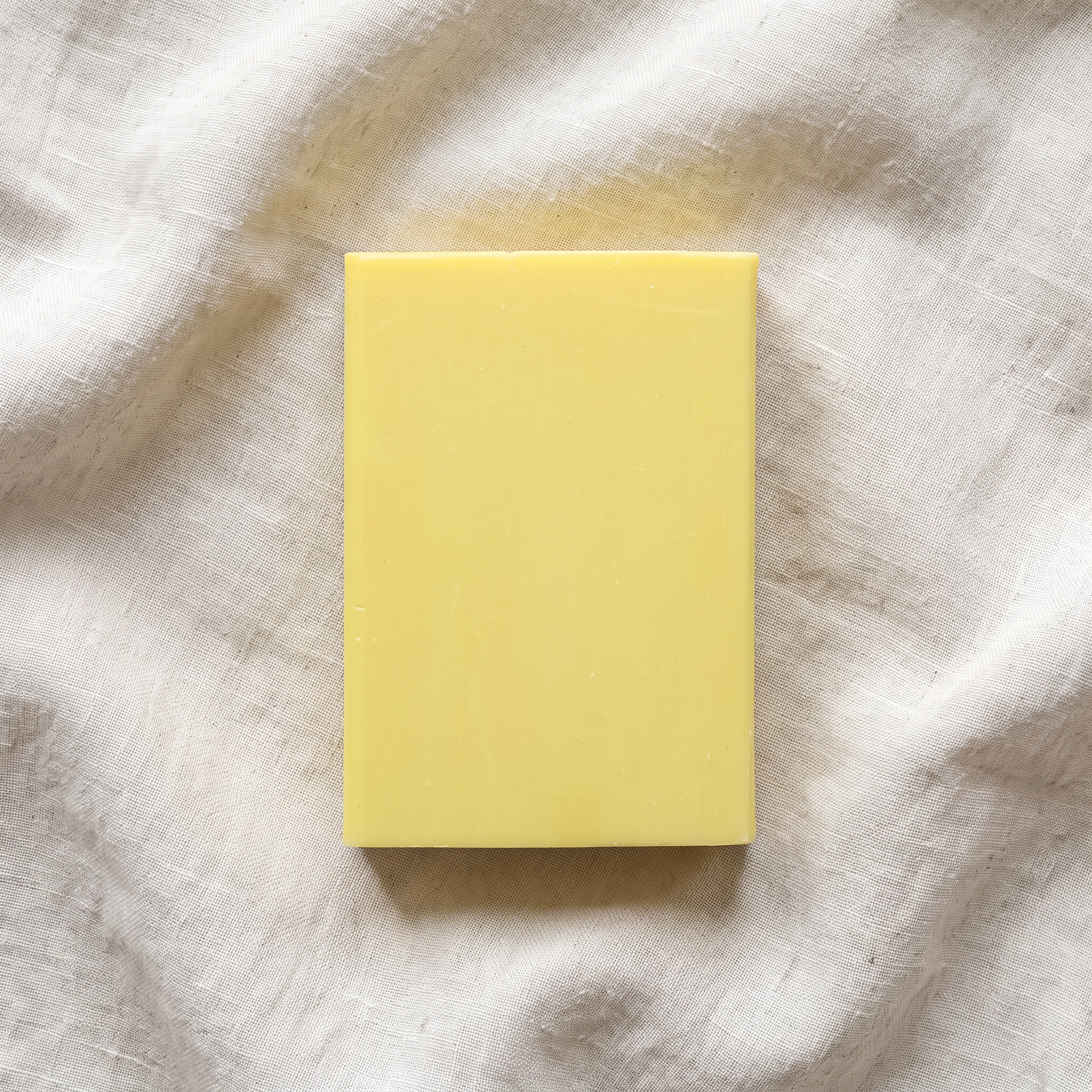 Overhead flat-lay of Sulfur Soap Bar on wrinkled natural linen, plain and unstyled