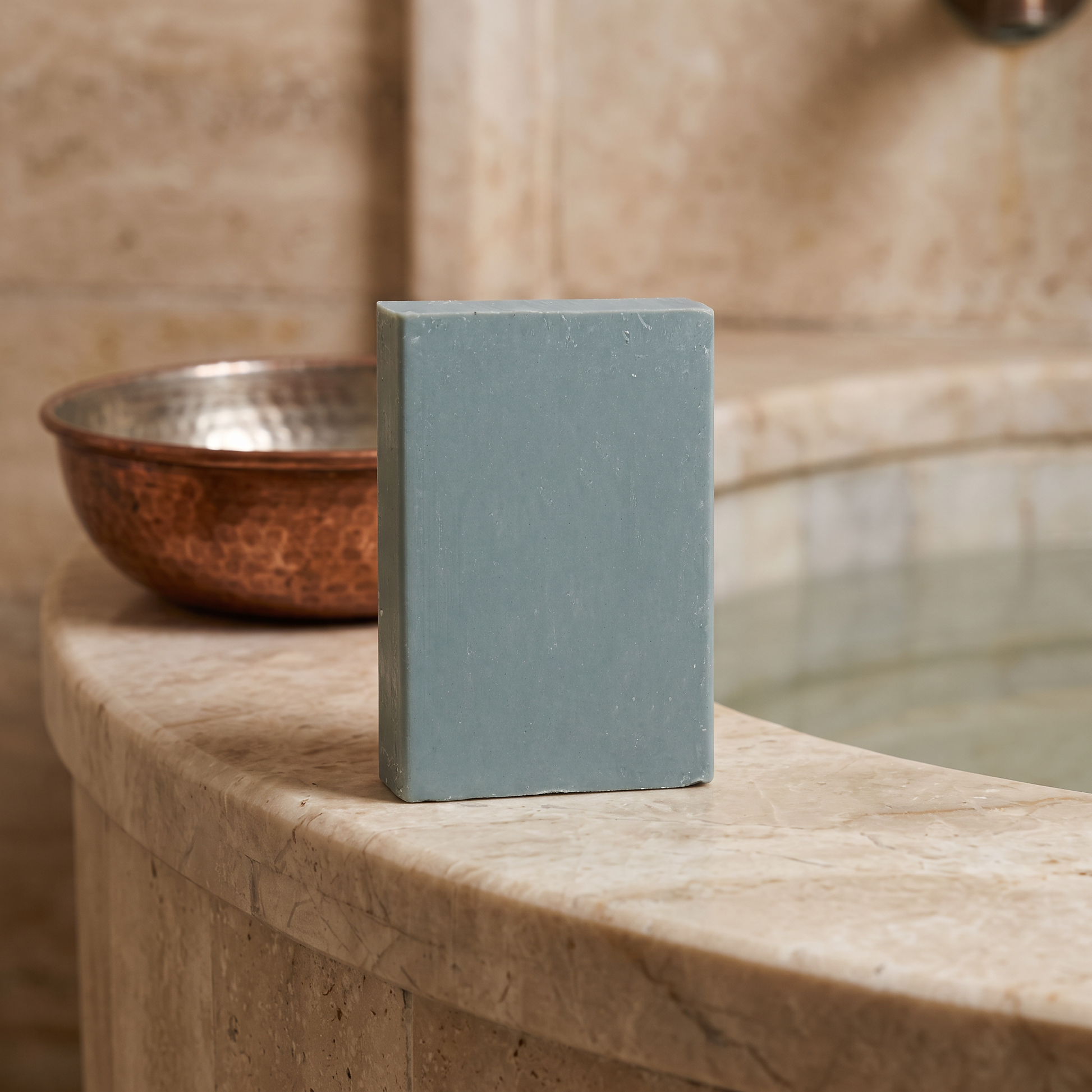 Avlia Retinol Soap Bar on marble hammam basin edge with copper bowl