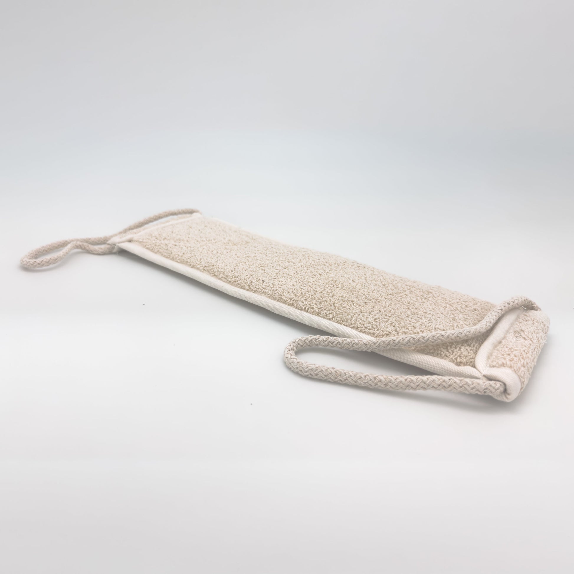 Reverse side of the Avlia loofah back scrubber showing full-length cream cotton terry face, the gentler surface for a second pass after exfoliating