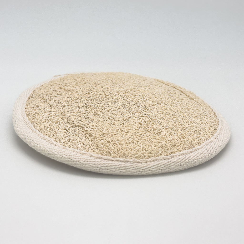 Round natural loofah pad front side, Luffa aegyptiaca exfoliating disc with cream cotton bias trim, handmade in Türkiye
