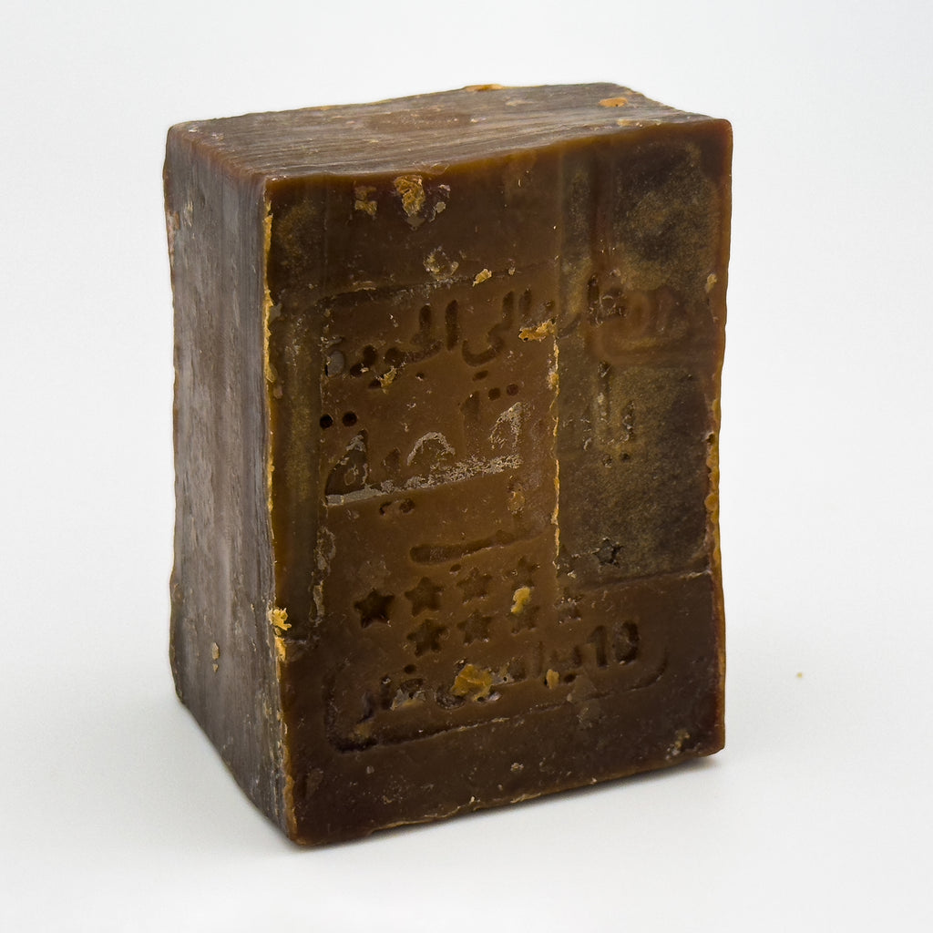 Side angle view of the rectangular Avlia Aleppo soap bar, highlighting its rustic texture and thickness Portrait