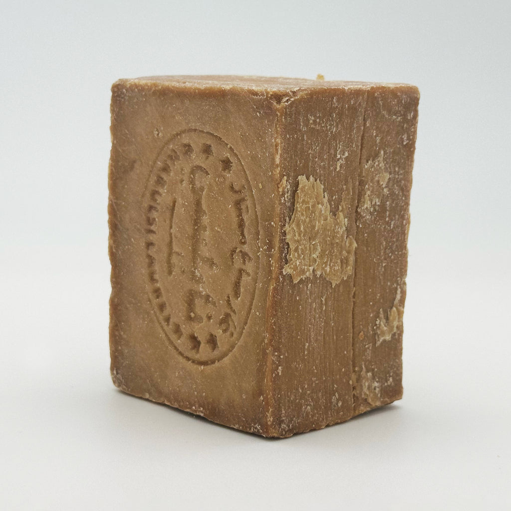 Side angle view of a standing Avlia Nablus soap bar showing rustic texture and stamped logo