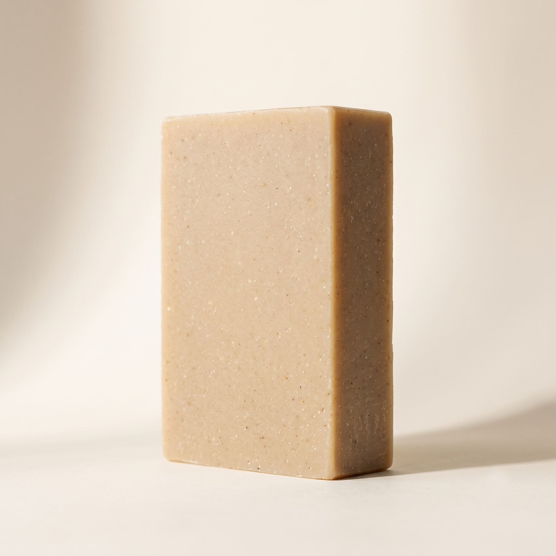 St. John's Wort Soap Bar shown at a three-quarter angle on a warm neutral studio backdrop, showing its amber-rose color
