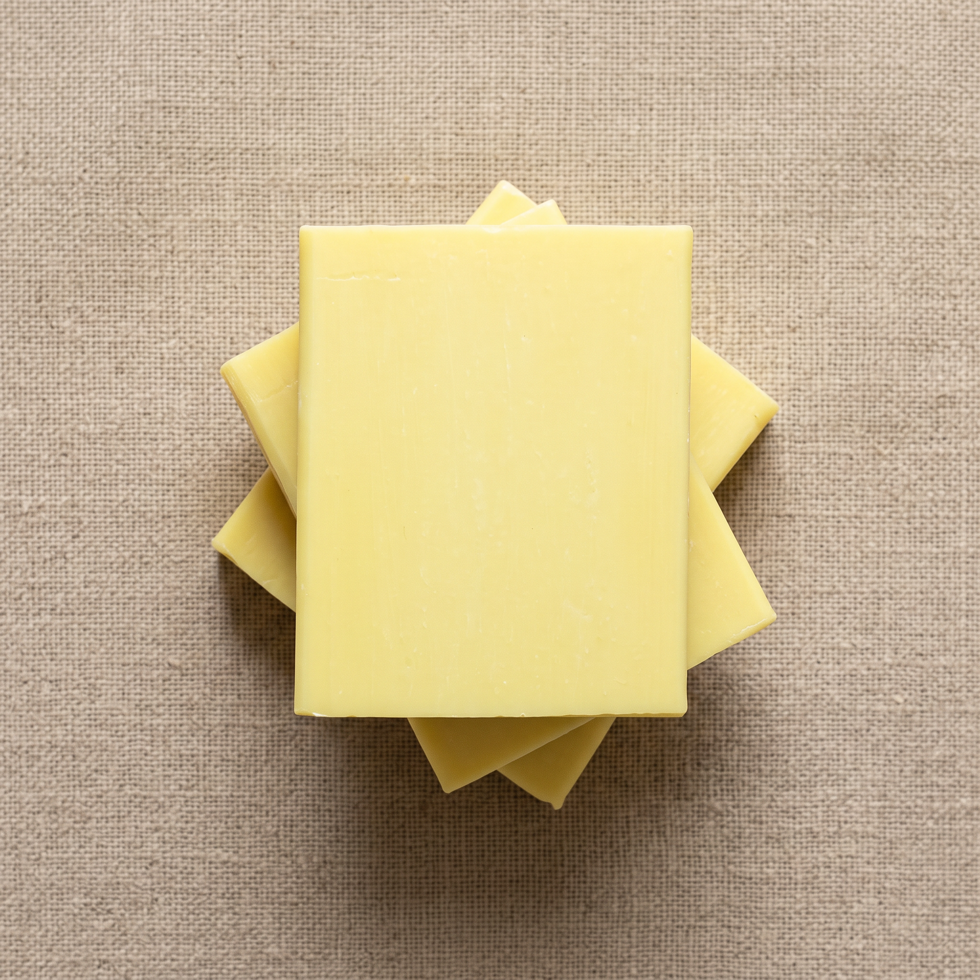 Three Lemon Soap Bars stacked on natural linen, showing the hand-cut edges