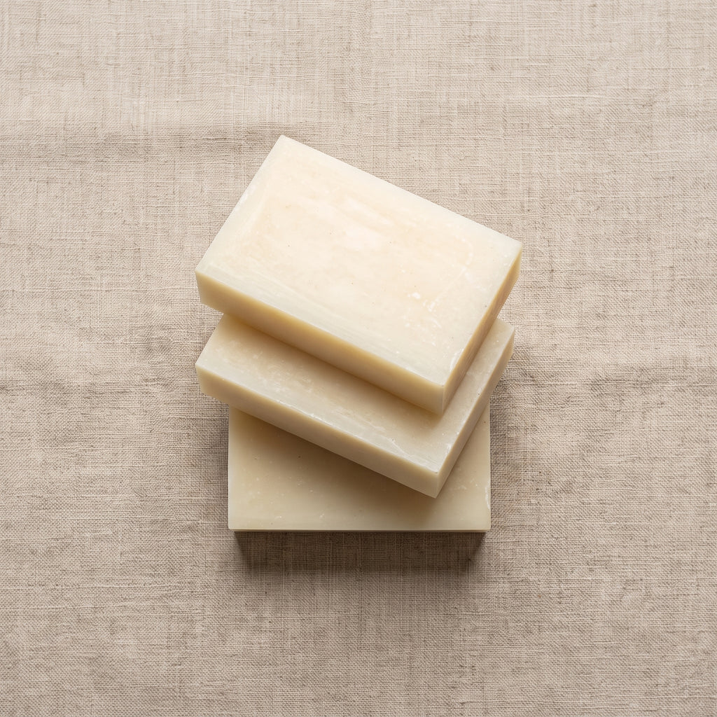 Three Rice Soap Bars stacked on natural linen, showing the hand-cut edges