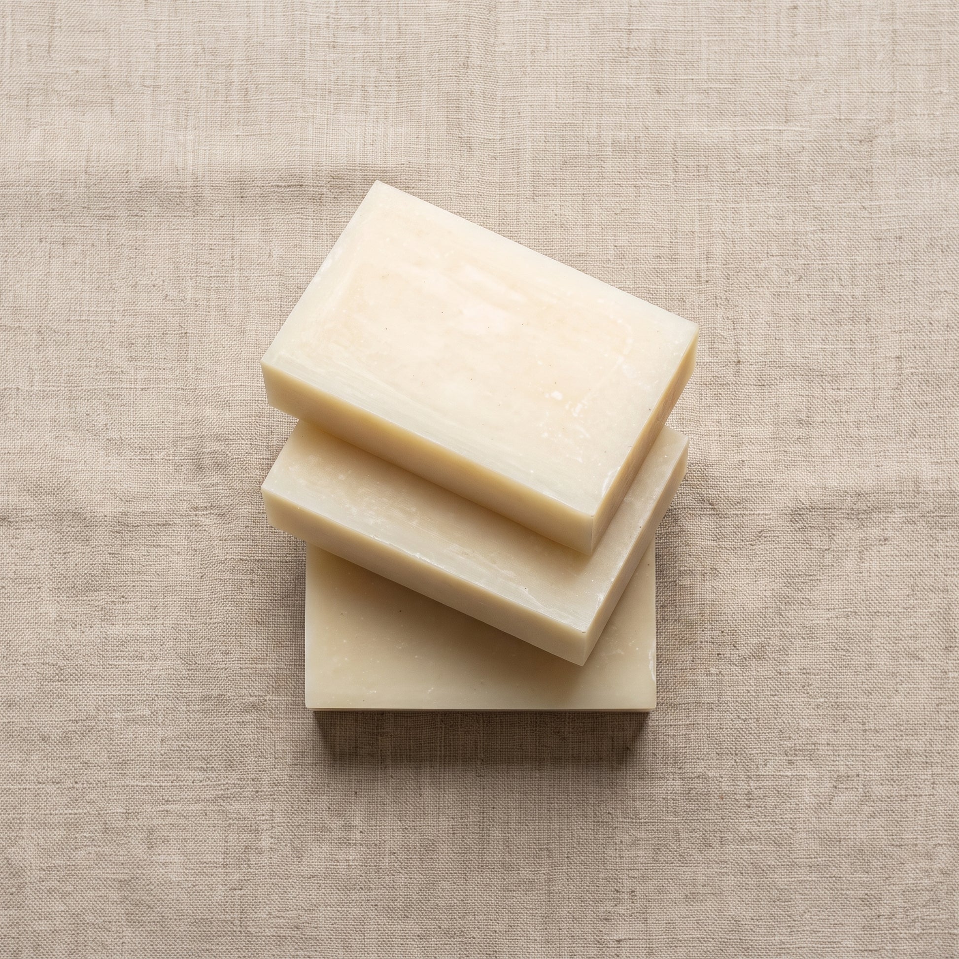 Three Rice Soap Bars stacked on natural linen, showing the hand-cut edges