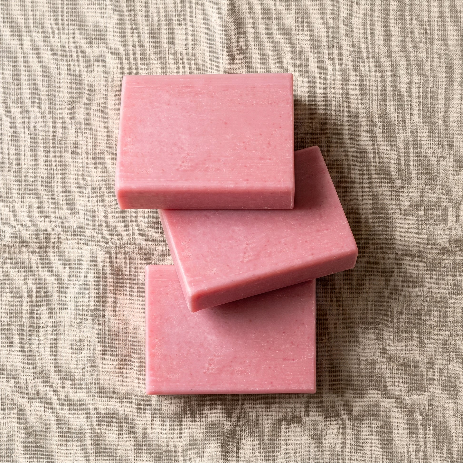 Three Rose Soap Bars stacked on natural linen, showing the hand-cut edges