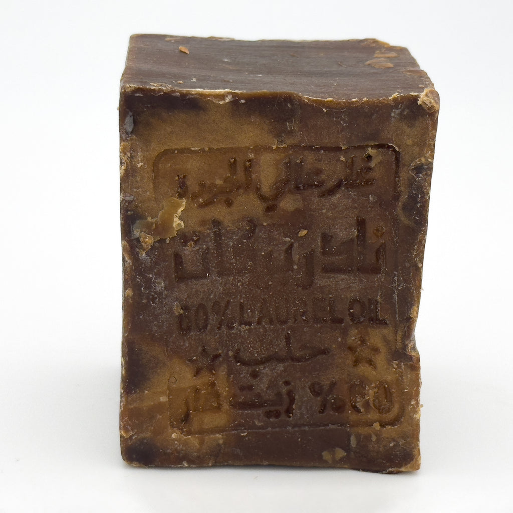 Top-down angled view of handmade Avlia Aleppo soap bar with visible 60% laurel oil markings
