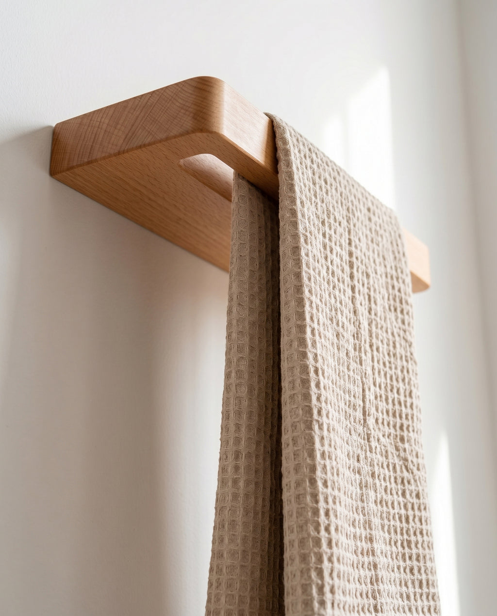 Underside view of wall-mounted Avlia beechwood towel shelf with white towel hanging down through slot, showing floating shelf mechanism from below