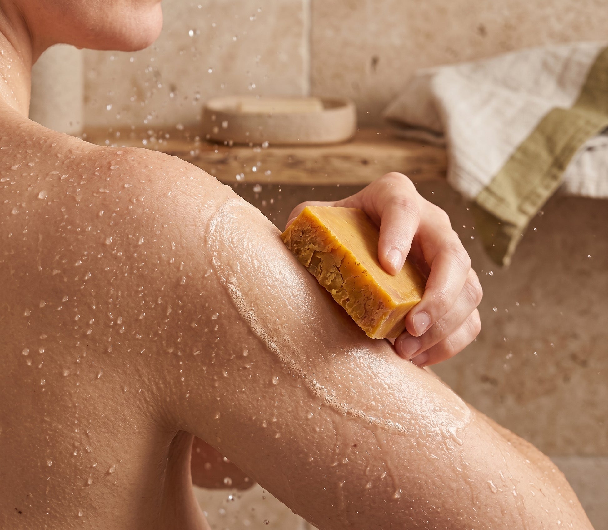 Using the Avlia Pure Sulfur Soap directly on wet skin, lather forming, natural bathroom light.